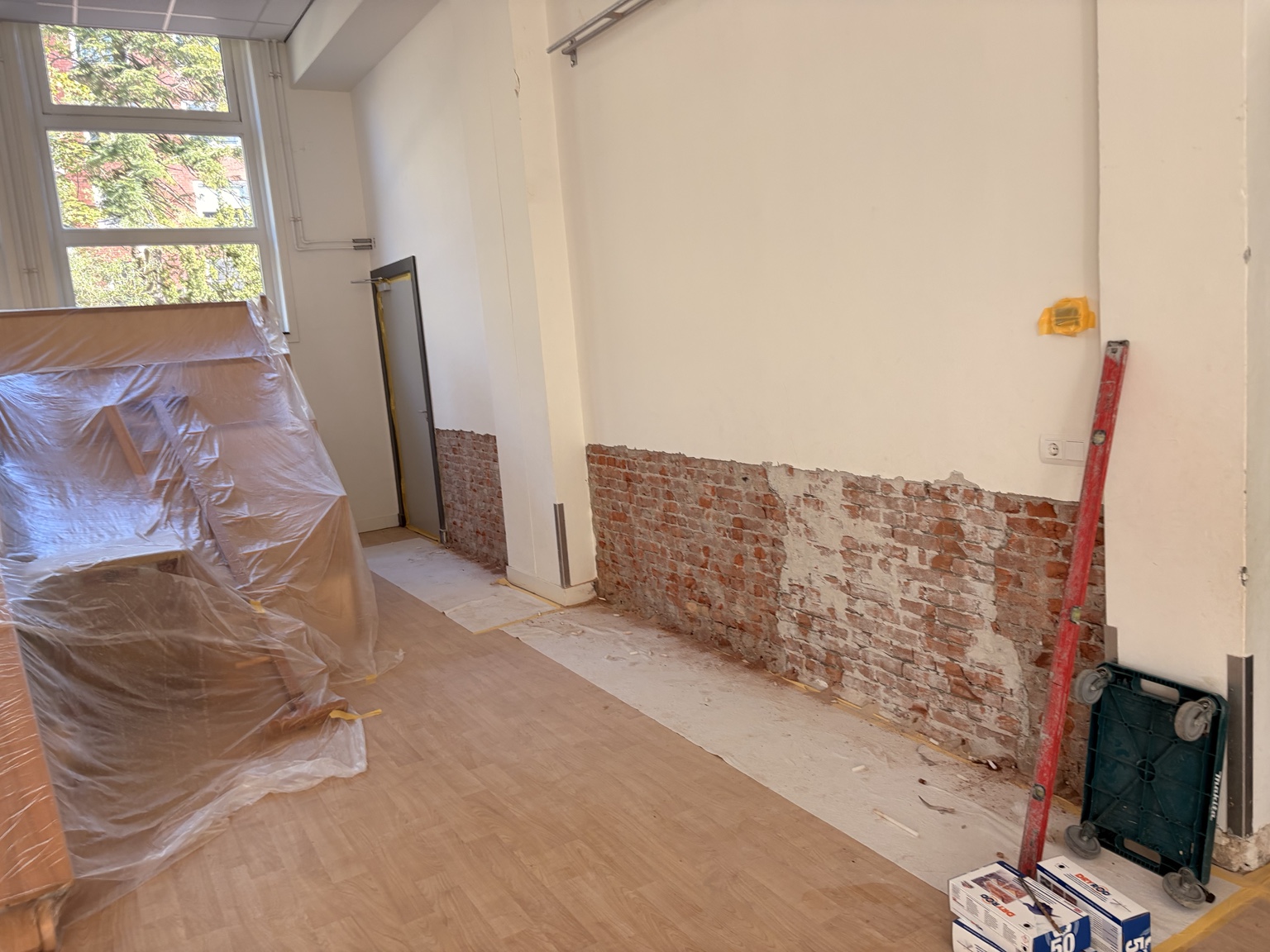 Vrijgelegd metselwerk rondom de deur, klaar voor de volgende behandeling
